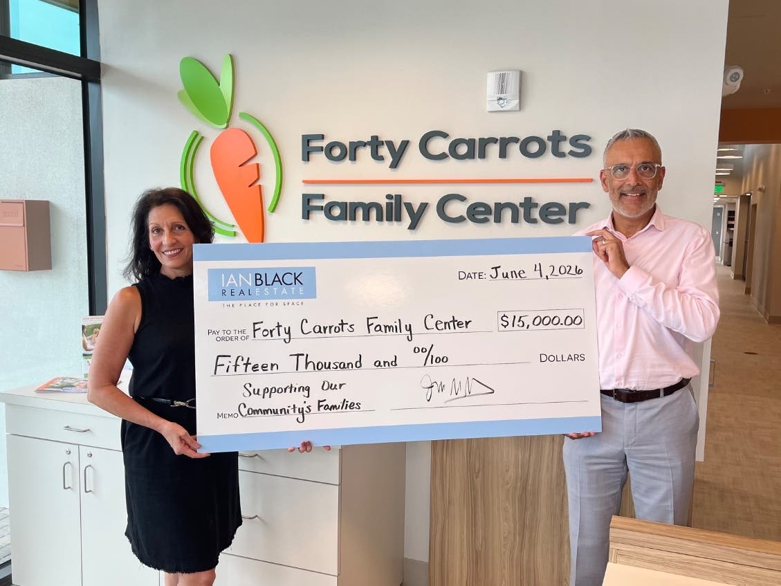 Michelle Kapreilian, CEO of Forty Carrots Family Center, and Jag Grewal, CCIM, SIOR, partner at Ian Black Real Estate, pose with a check for Forty Carrots Family Center