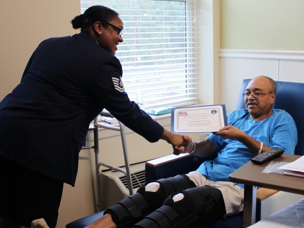 Air Force Tech Sgt. Akesha Lowry presents a certificate at an Honor Salute for Futurecare Landover patient Hoyt Gamble 