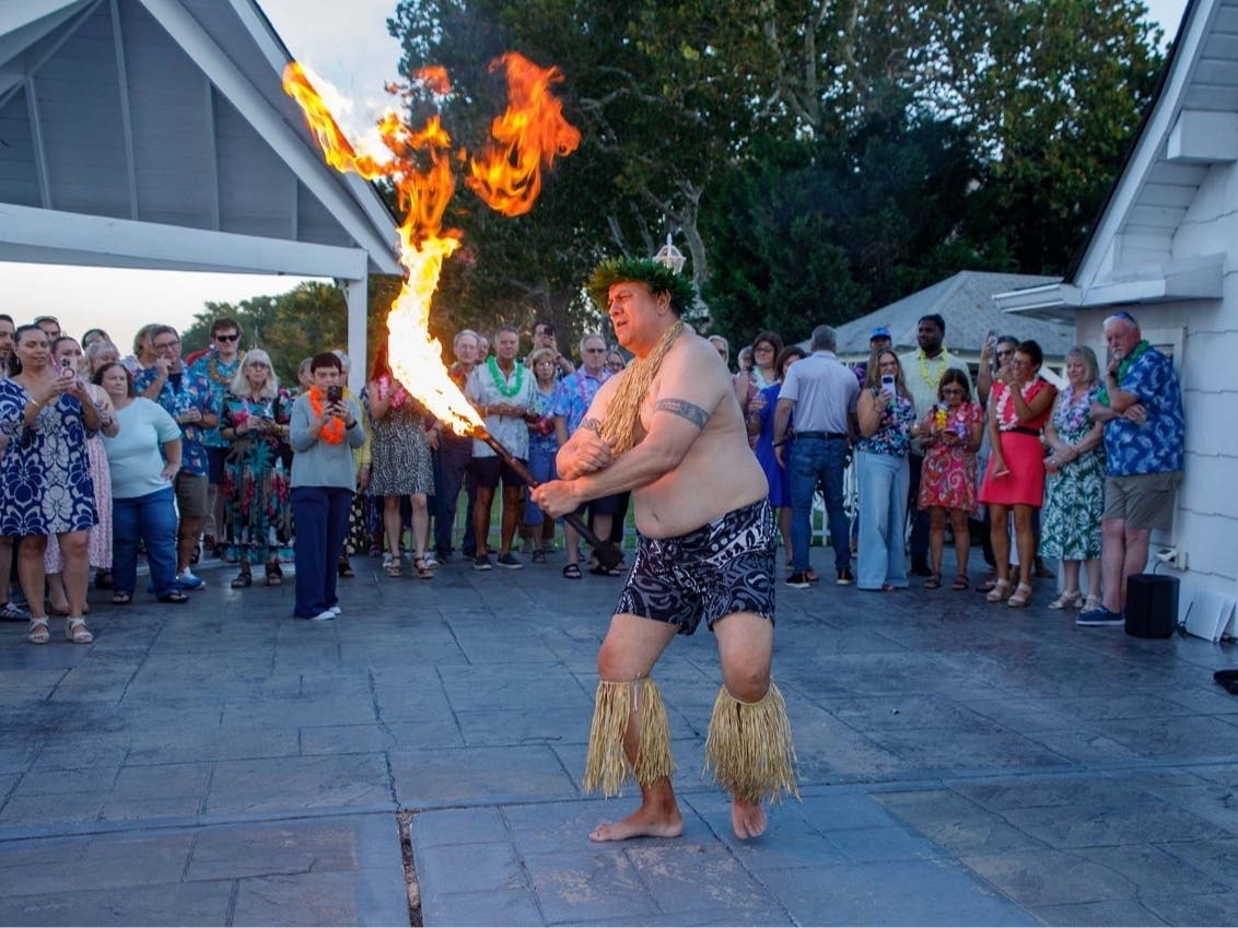 A member of Meki's Tamure Polynesian Arts Group performs a fire dance as guests look on at the Partners In Care End of Summer Luau held Oct. 1 at Kurtz’s Beach in Pasadena. 