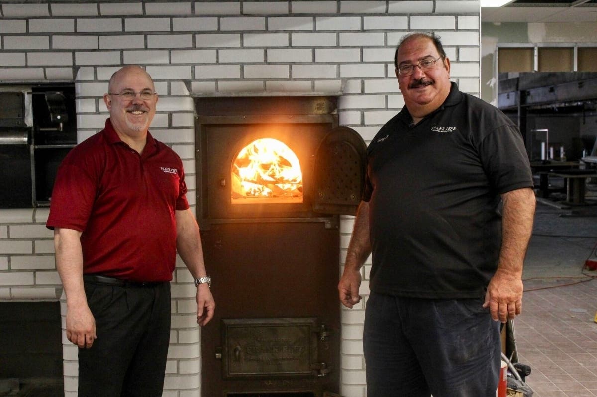 Chris Ruccio (left), GM of Pepe's in Burlington and Gary Bimonte co-owner and grandson of Frank Pepe, light the oven.
