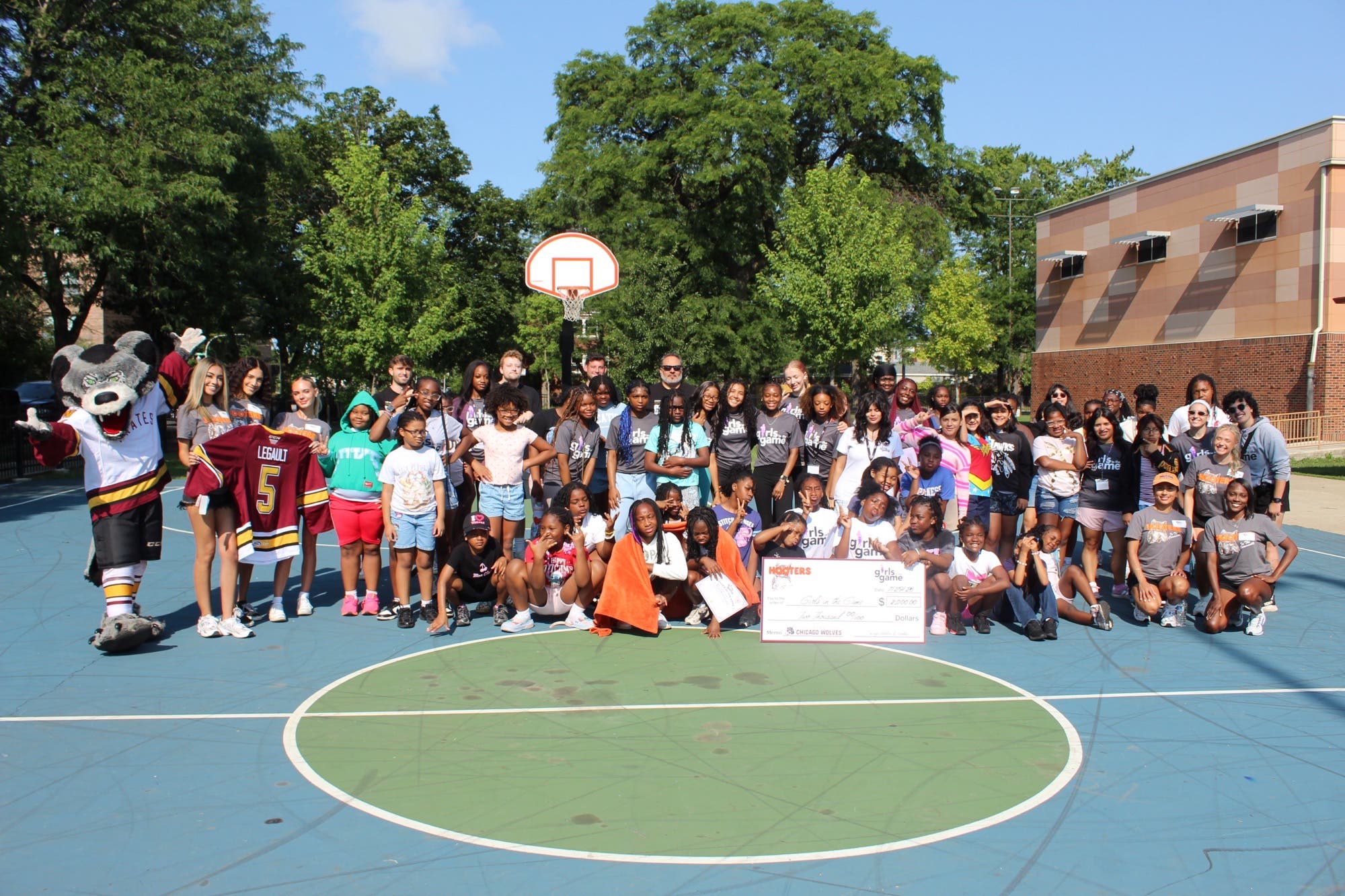 Hooters Presents Donation to Girls in the Game as part of Chicago Wolves “Score For Charity”
