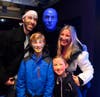 A family enjoys hanging out with a Blue Man after the show.