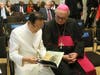 Dr. Hong, Tao-Tze, president of FOWPAL, left, shares a book with Bishop Camillo Ballin, Apostolic Vicar of Northern Arabia, during the World Leader Summit of Love and Peace. The book, titled “Be the Spark,” serves as a fine tool for conscience education.