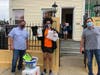 Brothers Brett Levin (left) and Andy Levin (right) of MHS Lift follow social distancing precautions while delivering a Rowan University sweatshirt and other fun items to MHS Lift Scholarship Fund recipient Jessica Rodriguez, 17, of Camden.