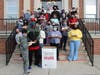 Desmond Newbill, Camden County Toys for Tots Coordinator with the Marine Corps Reserve, accepts the donation of dozens of hand-crafted wooden racecars from the students at Y.A.L.E. School Cherry Hill.