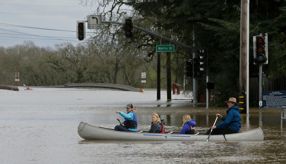 People use a canoe to make their way through floodwaters Wednesday, Feb. 27, 2019, in Sebastopol, California