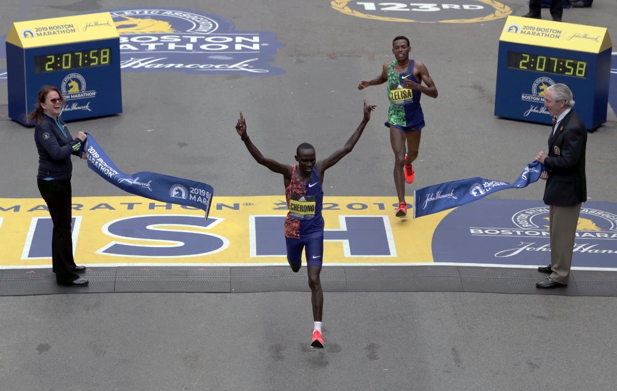 Lawrence Cherono, of Kenya, breaks the tape to win the 123rd Boston Marathon in front of Lelisa Desisa, of Ethiopia.