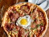 The Noble Pig features sweet fennel sausage, pepperoni, spicy soppressata, pickled peppers, caramelized onions, tomato sauce, fontina and Parmesan.