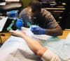 Artist Dionne Christopher works his magic on a customer. 