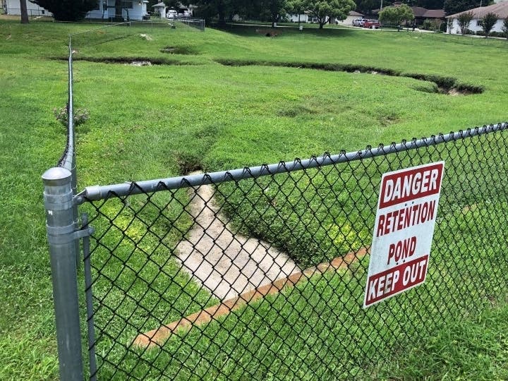 The depressions as well as some sinkholes that have opened up in the neighborhood lie on top of an underground cave system.