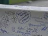 Members of the Taneja family write messages on the beam.