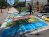 Artist Jay Giroux of the READ Movement painted the crosswalk mural featuring designs book titles selected by the school.