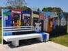 A bright-colored mural surrounds a bus stop. 