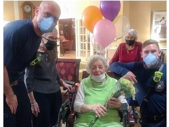 Palm Harbor firefighters Paul Holmes, left, and Riley Botts surprised Lenore "Lee" Crowley on her 100th birthday.