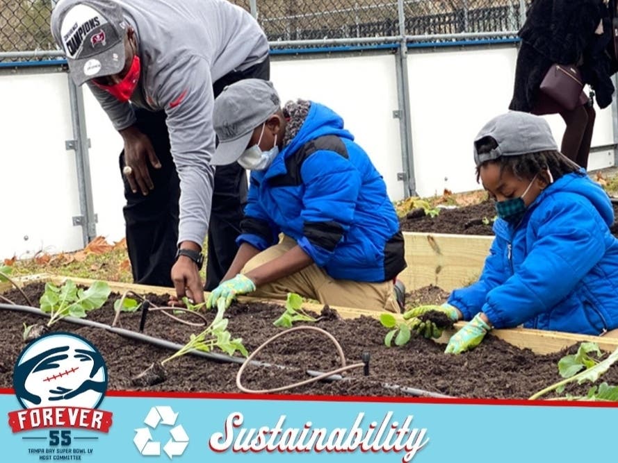 Professional bodybuilder Dexter "The Blade" Jackson helps kids from the Tampa Housing Authority construct a community garden and irrigation system with its microgrant funds. 