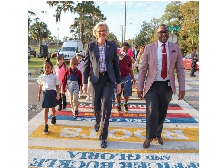Mayor Jane Castor walks with students and administrators across the painted crosswalk at the Dr. Carter G. Woodson PK-8 School.