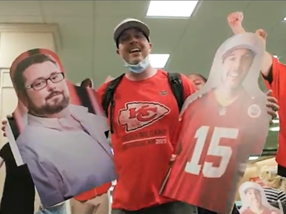 Clayton Whipple holds a cardboard cutout of himself in one hand and a cutout of his new Super Bowl buddy, L.J. Govoni, in the other at St. Pete, Clearwater International Airport. 