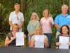 City and county officials hold up copies of the deed to the property.