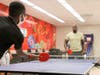WWE Superstar Titus O'Neil tries out the new ping-pong table at the new Innovation Lab at Pasco Middle School.