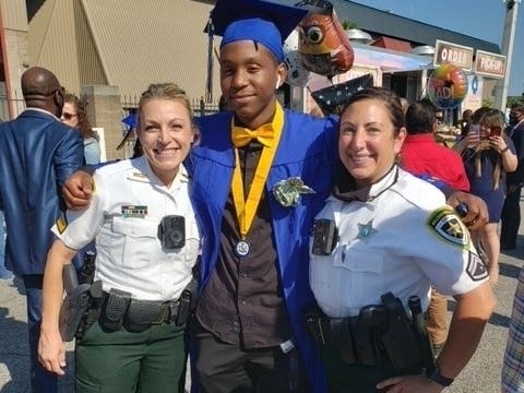 Hillsborough County Sheriff's Sgt. Kara Vance, left, and Cpl. Andrea Davis surprised Quintin Montgomery when they appeared at his graduation from Jefferson High School.