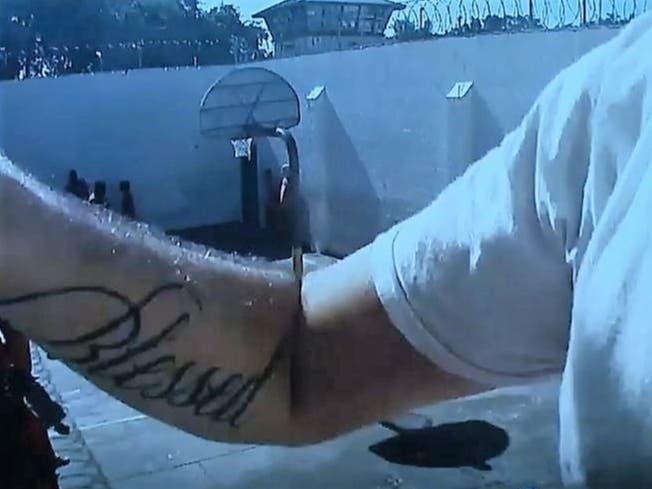 As fellow inmates play basketball and the detention deputy goes into the tower seen in the background to call deputies, Cody Jondreau is videotaped scaling the wall of the recreation yard. 