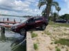 Police were notified that a car was precariously perched with the back end on the pavement and the front end hanging over the water. 