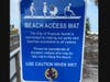 A sign publicizes the mobility mat on a beach in Treasure Island.