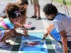 Kids took to the streets with paints and stencils to create an eye-catching street mural designed to make the crosswalks more visible.