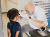 A student at Shore Elementary School undergoes an eye examination in the Mobile Vision Clinic by optician Stephen “Steve” Casto. 