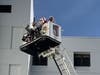 Santa greets children in the hospital from his perch in a fire bucket truck. 