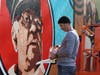 Muralist Jay Giroux puts the finishing touches on the new mural in Mcfarland Park.
