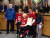 Alice Proctor, showing her new allegiance to the Tampa Bay Bucs by wearing a Bucs jersey, is recognized by the Pasco commission on her 100th birthday. 