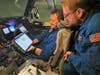 Lt. Cmdr. Robert Mitchell discusses the flight plan with flight director James Carpenter in the NOAA WP-3D Orion hurricane hunter aircraft, nicknamed Miss Piggy, before their early morning mission to Hurricane Ida Aug. 28, 2021.