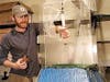 Christian Brown places a wandering salamander inside a wind tunnel box to study the creature's gliding technique.