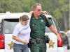 A sheriff's deputy leads an "injured" actor to safety.