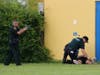 A police officer covers a team member who goes to the aid of an injured "student."
