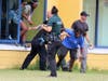 Law enforcement help students and staff escape through a classroom window.