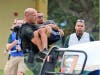 A mock rescue participant carries an "injured" actor to safety.