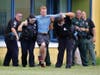 Law enforcement takes an "injured" student to the triage center located in the school parking lot.