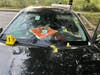 A photo shows more than a dozen bullets fired into the car, injuring a pregnant mother.