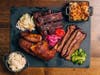 Mighty Quinn's BBQ offers a two- or three-meat platter with a choice of spare ribs, brisket, chicken, brontosaurus rib and sausage with a choice of sides.