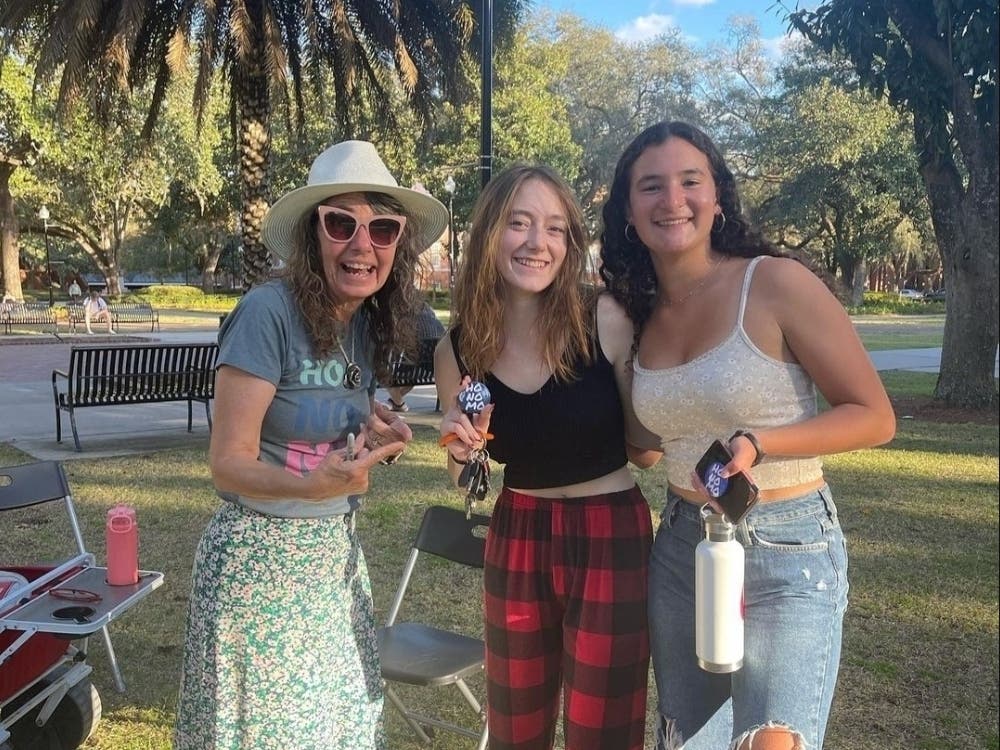 Cindy Smock takes photos with UF students after preaching.They love to gather with her to potentially earn "HONOMO" buttons. 