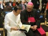 Dr. Hong, Tao-Tze, president of FOWPAL, left, shares a book with Bishop Camillo Ballin, Apostolic Vicar of Northern Arabia. The book, titled “Be the Spark,” serves as a fine tool for conscience education. 