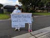 Tai Ji Men dizi, Lince Chu and his child hold a sign that reads, “Taiwan Must Revoke Illegal Auction of Tai Ji Men’s Property Now,” in Melbourne, Australia on August 15, 2020.