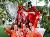 FOWPAL members joyfully interact with Moko Jumbie performers and two young ladies.
