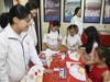 Attendees enjoy painting decorative fans. 
