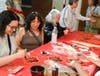Attendees happily write Chinese calligraphy.

