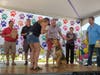 Supervisor O’Grady holds the mic for one of the Best Voice contestants while judges, (back, left to right) State Representative Bob Rita, Orland Township Trustee Antonio Rubio, professional dog trainer Angie DePalma and emcee Andy Avalos, look on