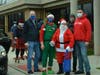 Orland Township Supervisor Paul O’Grady (left) Township Clerk Cindy Murray and Township Trustee Antonio Rubino get a little help from Santa and one of his elves at the Township’s Holiday Program distribution