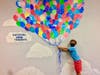 Second-grader Luca Gonzales poses with new Catching Thoughts balloon art display on Sept. 8. 